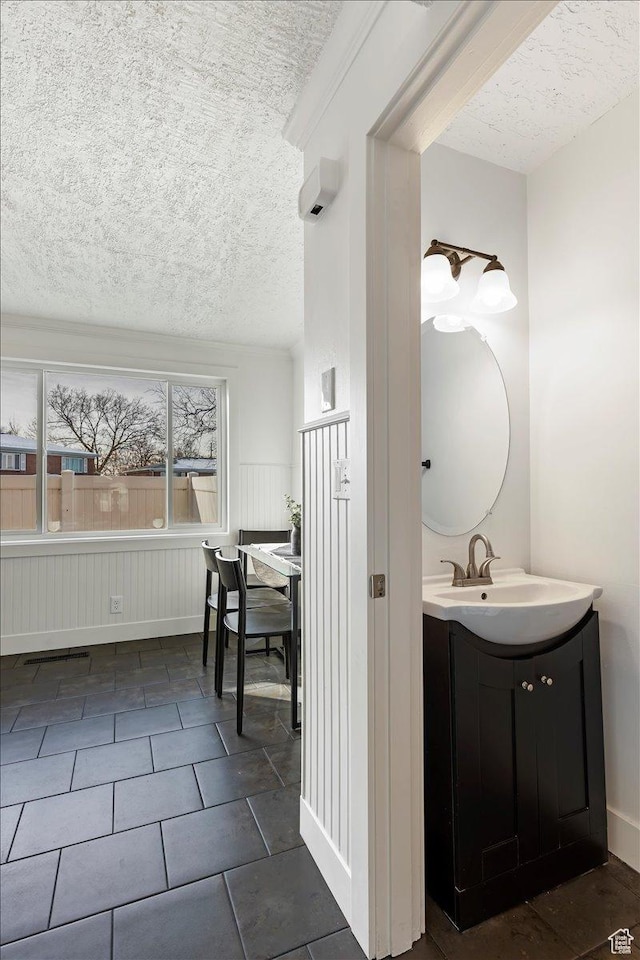 bathroom with tile patterned flooring, vanity, and a textured ceiling