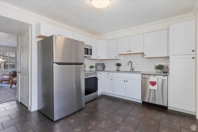 kitchen with backsplash, sink, a textured ceiling, appliances with stainless steel finishes, and white cabinetry
