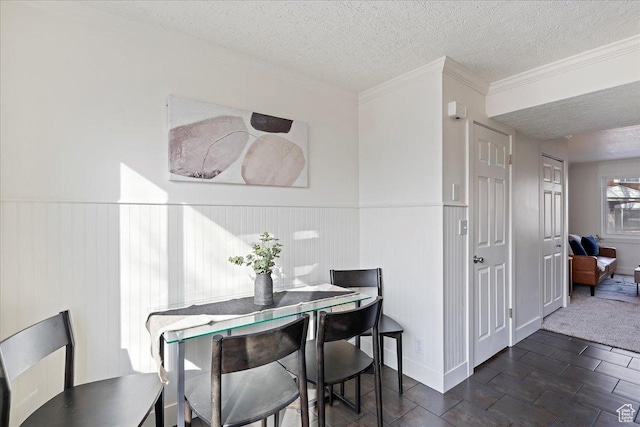 dining space featuring ornamental molding and a textured ceiling