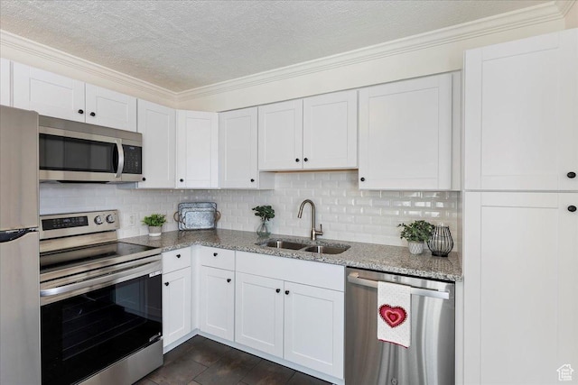 kitchen featuring sink, a textured ceiling, appliances with stainless steel finishes, light stone counters, and white cabinetry