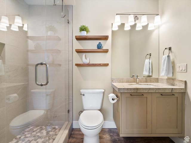 bathroom featuring vanity, toilet, and a stall shower
