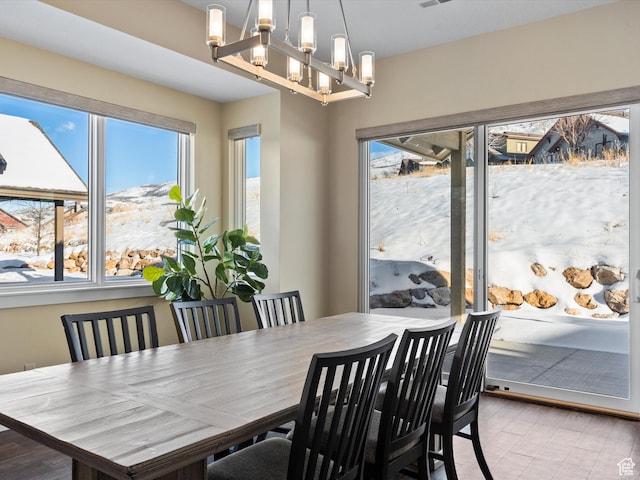 dining area with an inviting chandelier, wood finished floors, and a wealth of natural light
