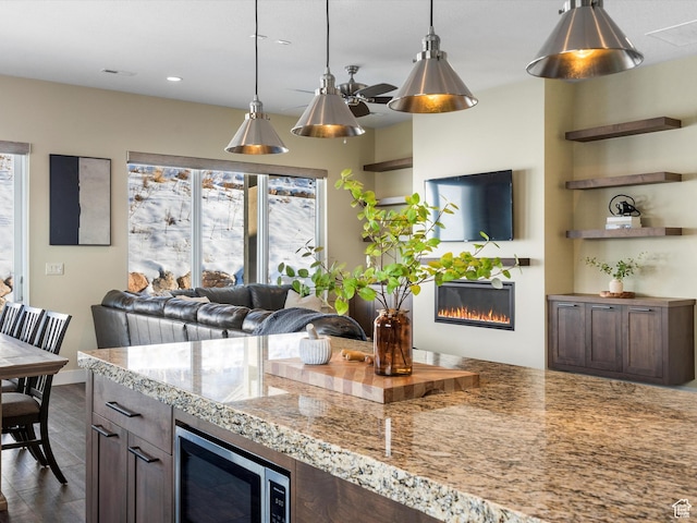 kitchen with visible vents, a glass covered fireplace, recessed lighting, stainless steel microwave, and hanging light fixtures