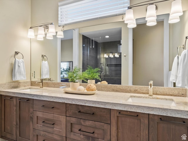full bath featuring double vanity, a sink, and a shower stall