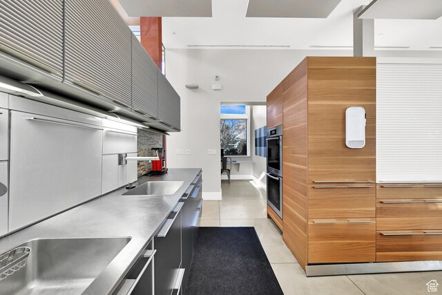 1762 E Millcreek Way, Millcreek, UT 84106 - kitchen with stainless steel countertops, modern cabinets, light tile patterned floors, and tasteful backsplash