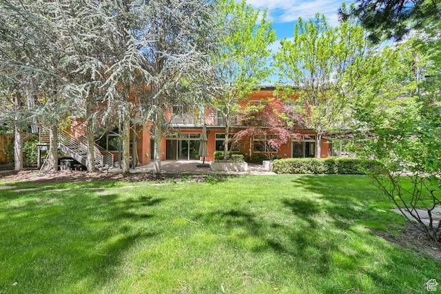 1762 E Millcreek Way, Millcreek, UT 84106 - rear view of property featuring a patio, a lawn, and stairs