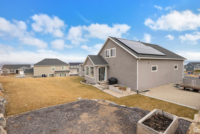 536 W Granite Cir, Saratoga Springs, UT 84045 - back of property featuring a yard, a garden, solar panels, and stucco siding