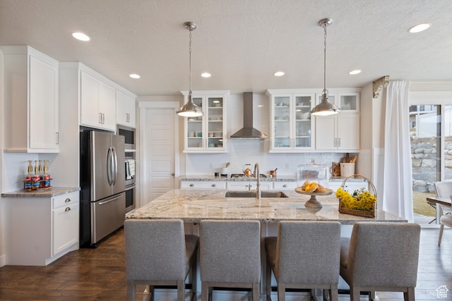 536 W Granite Cir, Saratoga Springs, UT 84045 - kitchen featuring white cabinets, a sink, a kitchen breakfast bar, wall chimney exhaust hood, and stainless steel appliances