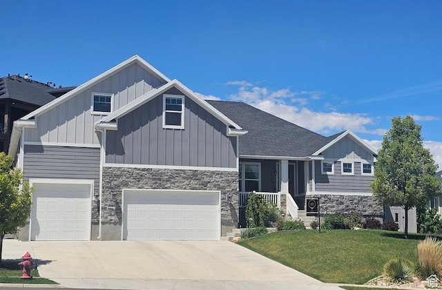 536 W Granite Cir, Saratoga Springs, UT 84045 - view of front of home featuring an attached garage, stone siding, board and batten siding, a front yard, and driveway