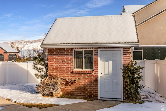 2783 S Irene Dr E, Bountiful, UT 84010 - snow covered property entrance with stucco siding, brick siding, fence, and a mountain view