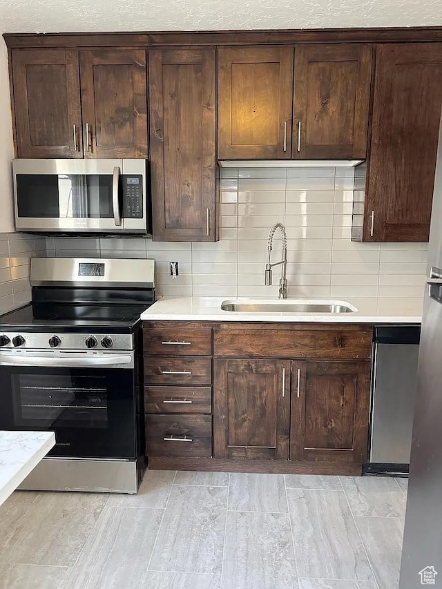 793 N 1200 W, Salt Lake City, UT 84116 - kitchen with appliances with stainless steel finishes, light countertops, decorative backsplash, and a sink