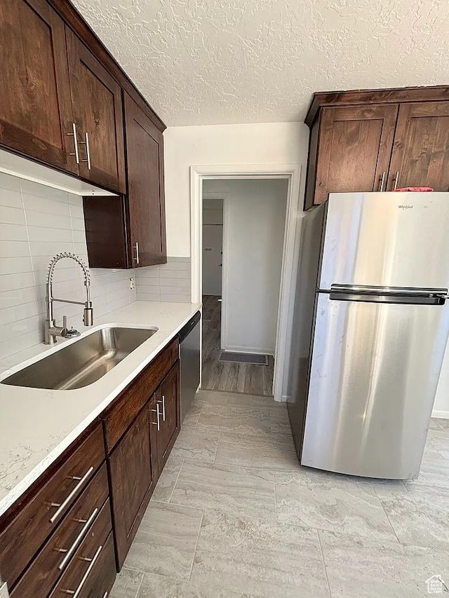 793 N 1200 W, Salt Lake City, UT 84116 - kitchen featuring a sink, decorative backsplash, stainless steel appliances, dark brown cabinetry, and light countertops