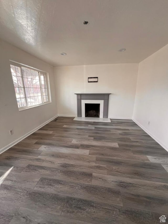 793 N 1200 W, Salt Lake City, UT 84116 - unfurnished living room featuring baseboards, recessed lighting, a fireplace with raised hearth, and dark wood-type flooring