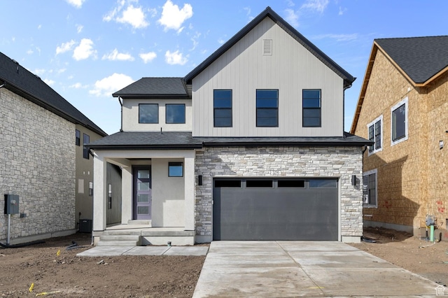 view of front facade with stone siding, concrete driveway, and a garage