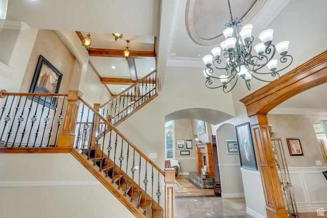 staircase with ornamental molding and a towering ceiling