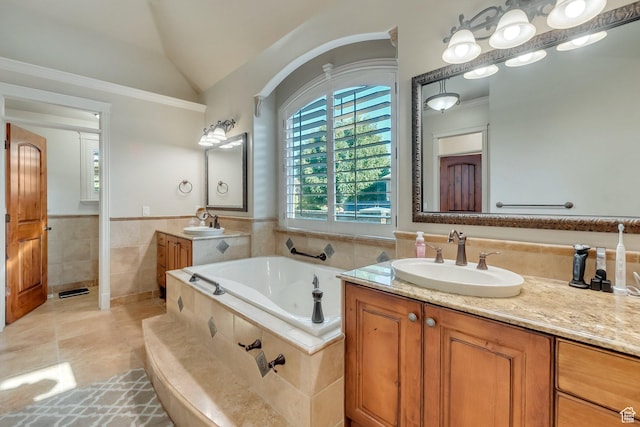 bathroom featuring lofted ceiling, tiled tub, tile patterned floors, tile walls, and vanity