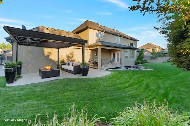 rear view of property featuring a yard, a patio area, and an outdoor living space with a fire pit