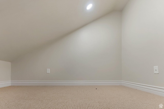 additional living space with vaulted ceiling and carpet flooring