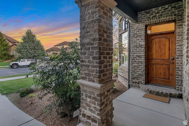 exterior entry at dusk featuring covered porch