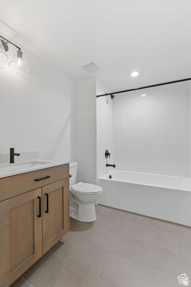 full bathroom featuring tile patterned floors, vanity, toilet, and tiled shower / bath