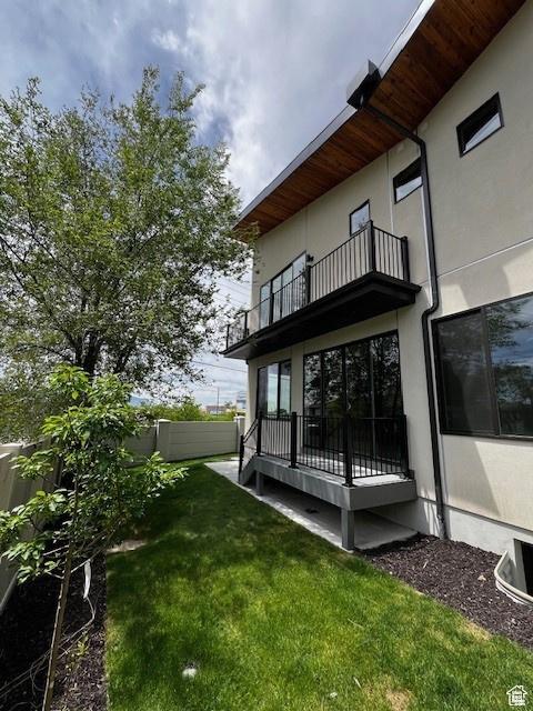 exterior space with a lawn and a balcony