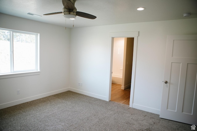 carpeted empty room featuring ceiling fan