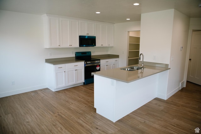 kitchen featuring white cabinetry, sink, black electric range oven, kitchen peninsula, and light wood-type flooring