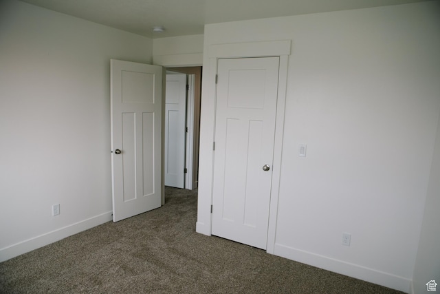 unfurnished bedroom with dark carpet