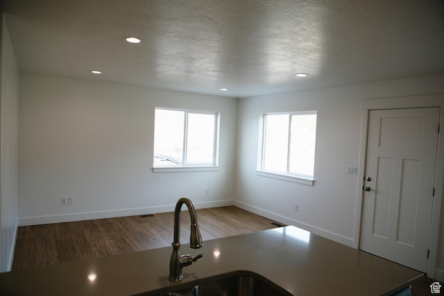 kitchen featuring a textured ceiling and hardwood / wood-style flooring