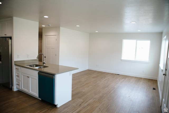 kitchen with stainless steel refrigerator, white cabinetry, dishwasher, sink, and hardwood / wood-style floors