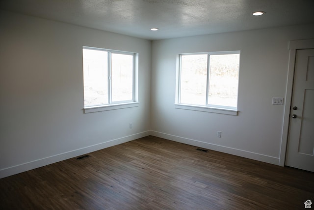 unfurnished room with dark wood-type flooring