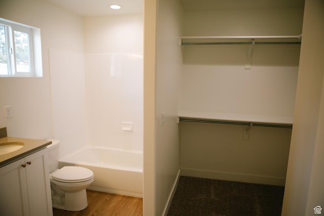 full bathroom featuring hardwood / wood-style flooring, vanity, shower / bath combination, and toilet