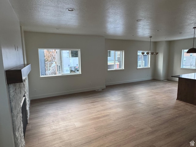 4883 E 3525 N, Eden, UT 84310 - unfurnished living room featuring a fireplace, a textured ceiling, and light wood-type flooring