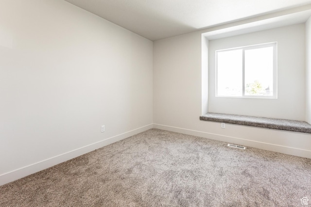 carpeted empty room featuring baseboards