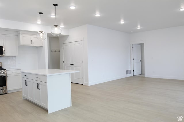 626 E 2450 N, North Logan, UT 84341 - kitchen featuring stainless steel stove, light wood-style flooring, backsplash, light countertops, and white cabinets