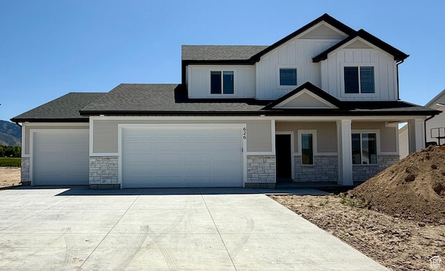 626 E 2450 N, North Logan, UT 84341 - view of front facade featuring stone siding, driveway, covered porch, board and batten siding, and a shingled roof