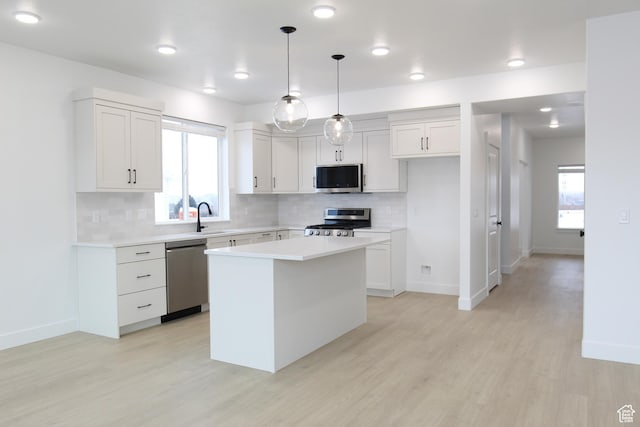 626 E 2450 N, North Logan, UT 84341 - kitchen featuring stainless steel appliances, a sink, decorative backsplash, light wood-type flooring, and light countertops