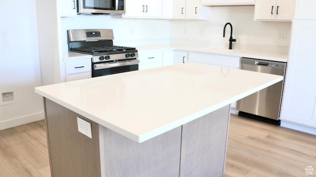 11199 S Rummy Way Unit 319, South Jordan, UT 84009 - kitchen with a center island, white cabinets, stainless steel appliances, and light wood-type flooring