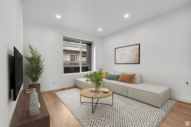 living room with recessed lighting, light wood-type flooring, and baseboards