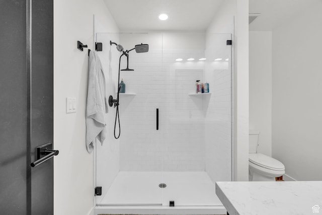 bathroom featuring a stall shower, toilet, and vanity