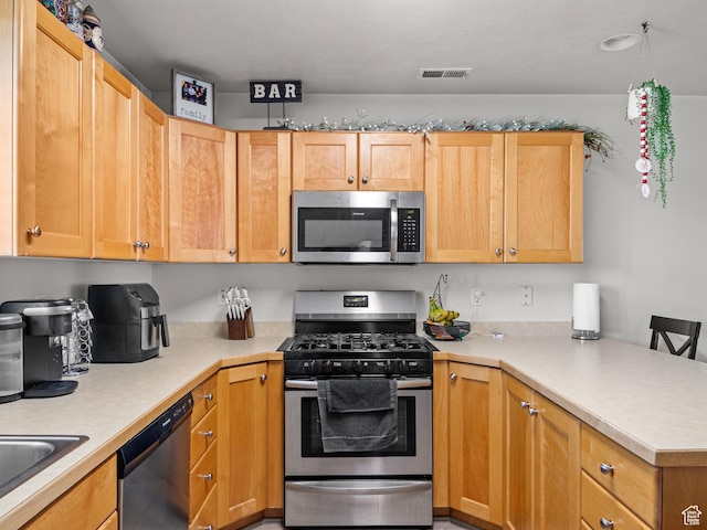 kitchen featuring kitchen peninsula, sink, stainless steel appliances, and a breakfast bar