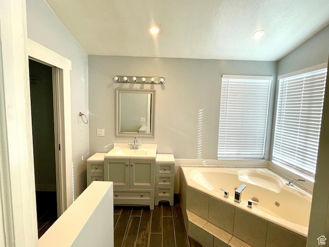 1668 N Lewis And Clark Dr, Centerville, UT 84014 - bathroom featuring a textured ceiling, a jetted tub, wood finished floors, and vanity
