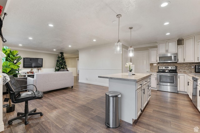 kitchen with light stone countertops, stainless steel appliances, crown molding, pendant lighting, and a kitchen island