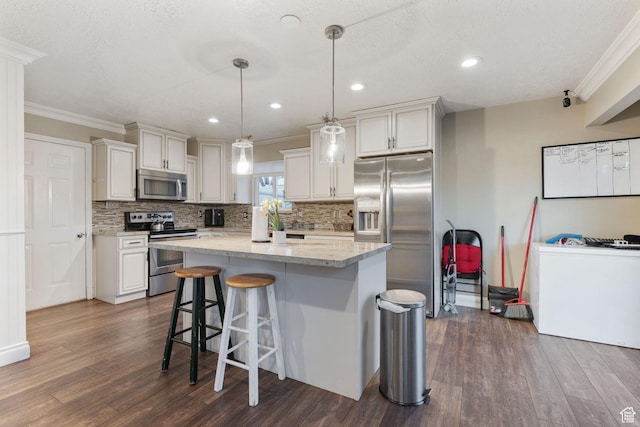 kitchen featuring a center island, stainless steel appliances, light stone counters, pendant lighting, and a breakfast bar