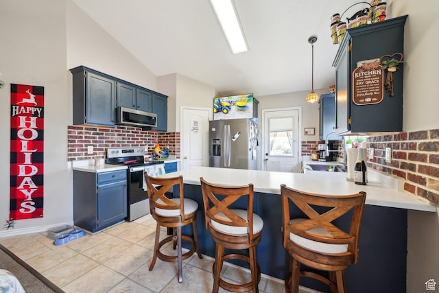 kitchen with kitchen peninsula, appliances with stainless steel finishes, backsplash, decorative light fixtures, and lofted ceiling