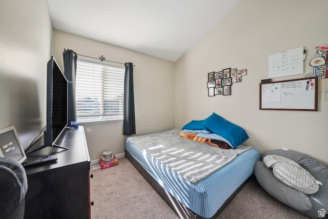 bedroom with lofted ceiling and light carpet