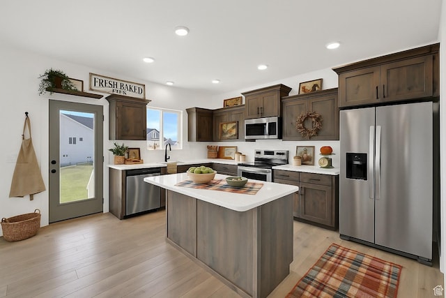 1317 N 1850 W, Clinton, UT 84015 - kitchen featuring stainless steel appliances, dark brown cabinets, light countertops, light wood finished floors, and a center island