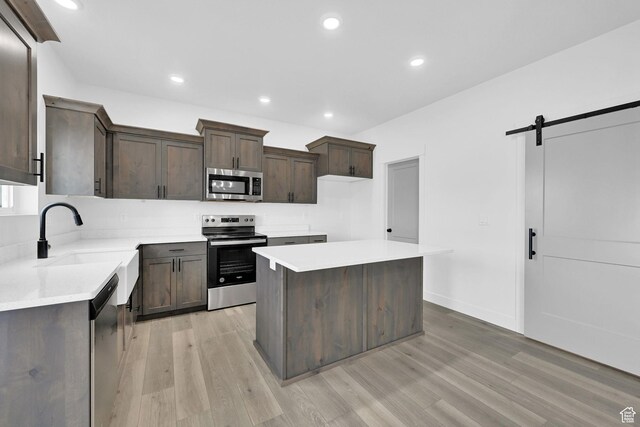 1317 N 1850 W, Clinton, UT 84015 - kitchen with appliances with stainless steel finishes, a sink, dark brown cabinetry, light wood-style floors, and light countertops