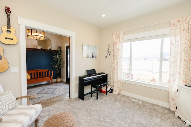 living area featuring light carpet and radiator heating unit