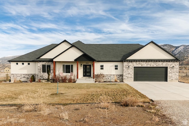craftsman house with a mountain view, a garage, and a front yard